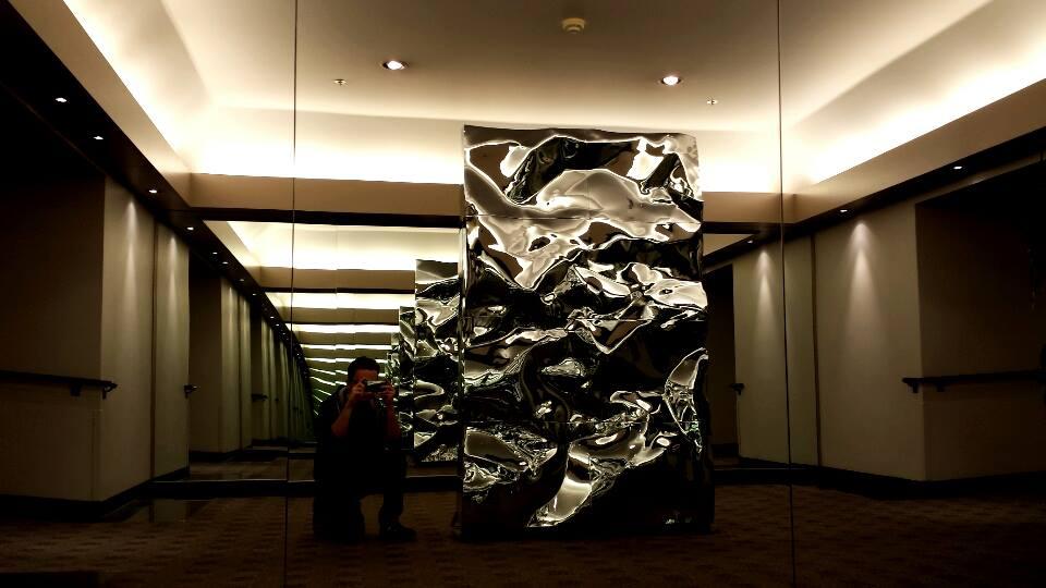 A large metal sculpture between two mirrors