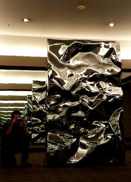 A large metal sculpture between two mirrors